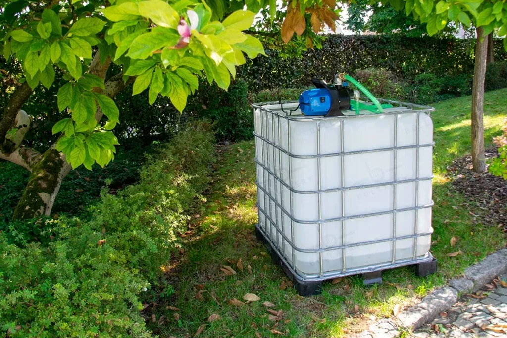 IBC container met waterpomp op metalen of kunststof pallet - praktische regenton 1000 liter
